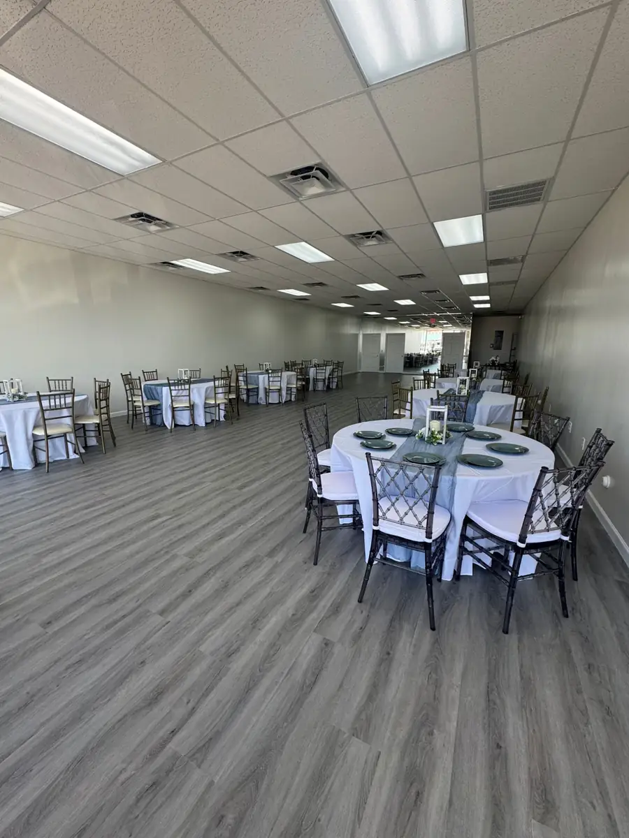 The Vellora Venue hall set with round tables, white linens and chiavari chairs